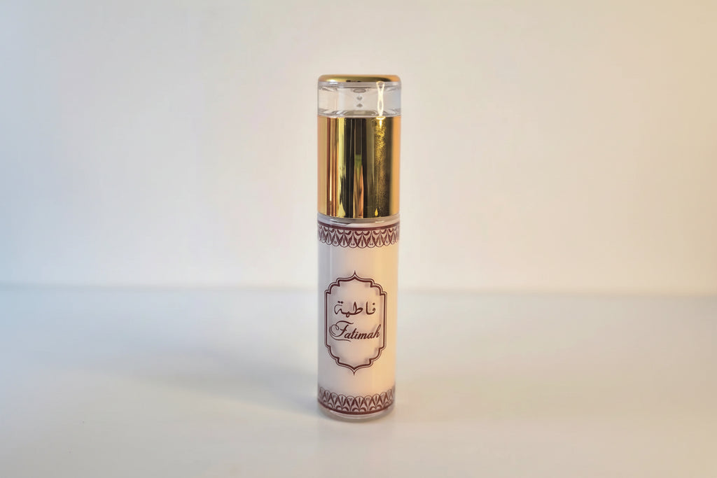 Perfume bottle with gold cap and white label on a light gray background